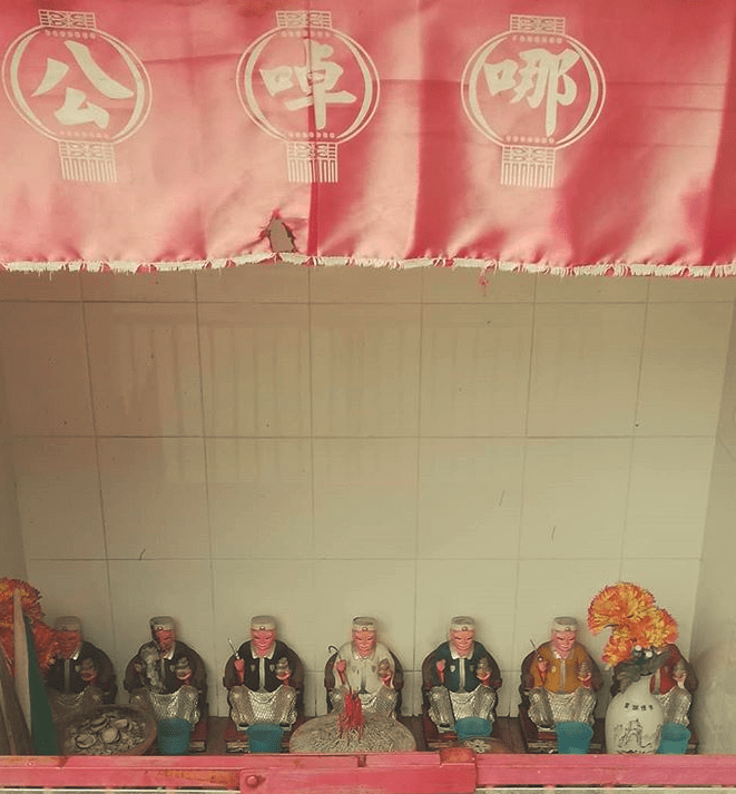 Statuettes lined up in a shrine.
